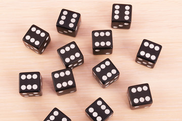Black game dice showing the six on all face.Many cubes for board games on light...