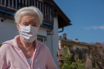 Senior woman with face mask in the garden
