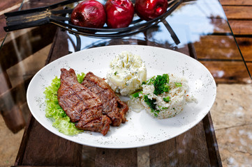 Beef steak with potatoes and rice in isolated white background
