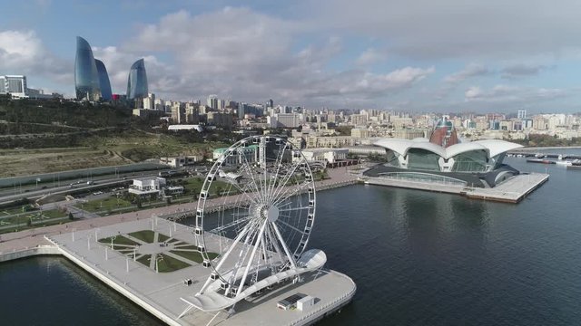 View of Ferris wheel. Amusement park in evening. Ferris wheel top view at night. View of the Baku city. Famous Ferris wheel night silhouette in Baku. Ferris wheel vintage best city and promenade view.