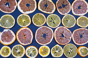 Dried slices of oranges and grapefruit on a blue background.