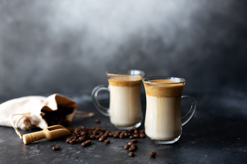 Fototapeta na wymiar Two glass cups with Dalgona frothy coffee trend korean drink latte espresso with coffee foam on black background