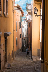 Fototapeta na wymiar A young woman walking in the streets of Bellagio Italy (Salita Camillo Benso Conte Di Cavour)