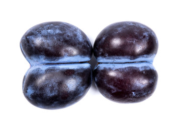 Fresh blue plums, isolated on white background, in close-up.