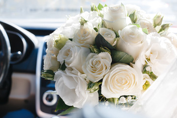 Bridal bouquet of white roses in a car interior