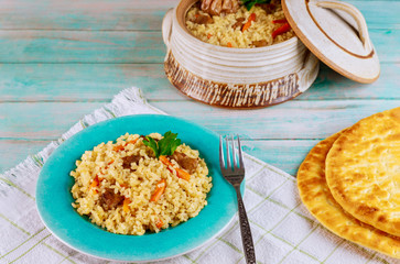 Uzbek rice with meat, carrot and garlic in clay pot.