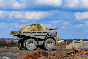 Obraz premium Huge dump truck loaded with iron ore on a gravel road
