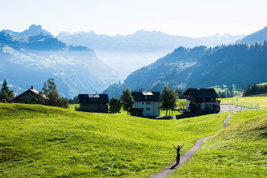 Woman on a walking path high up in the alps in Stoos Switzerland.