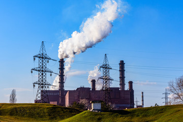 View on smoke pipes of the factory against blue sky. Environmental pollution