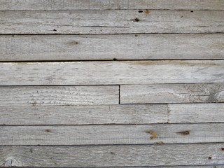 Light gray wooden horizontal boards with rust spots texture.