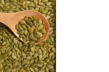 Peeled Pumpkin Seeds. Unshelled kernels. Nuts lie in a wooden spoon.