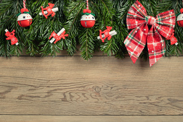 Christmas tree branches with red decorations on a wooden wall background. Template for greeting card or design. Horizontal banner with copy space