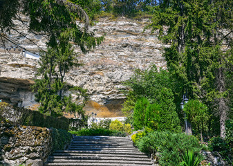 Stone stairs in a beautiful park at the foot of a high cliff