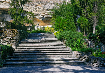 Stone stairs in a beautiful park at the foot of a high cliff