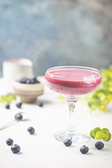 Homemade antioxidant summer blueberry smoothie in a glass on white table