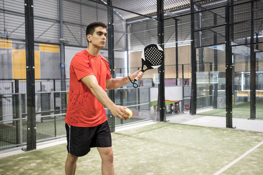 Paddle tennis player ready for serve in court