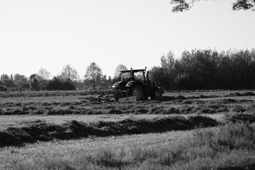 Naklejka premium tractor in a field mowing
