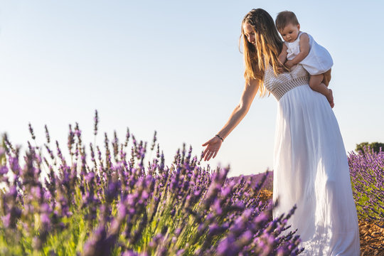 Mother and Baby Having Fun in a Field of Flowers.