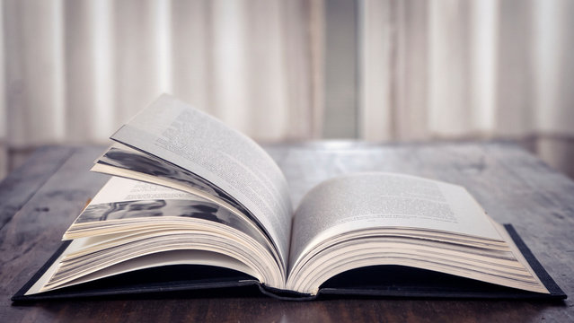 Open book over wooden table. Library. Literature. Read. Study.