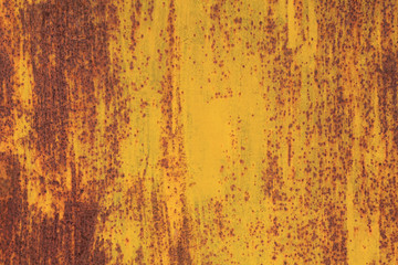 Metallic wall background, texture, colored in fiery yellow color. Old rusty metal surface with faded uneven color in the form of flames strokes. Abstract sketches and colors of old walls and fences