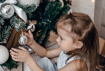 
Little girl decorate with Christmas tree balls