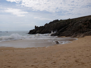 Fototapeta na wymiar Une plage de sables fin avec la côte rocheuse surplombant la mer