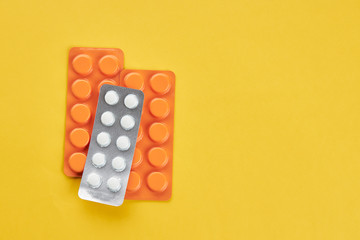 medical wellness concept. orange pills on a yellow background. copy space. minimal.