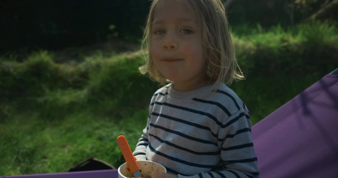 Preschooler eating lunch on sun longer in garden in the spring