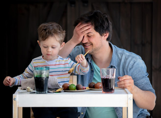 Father and son painting easter Eggs on a table