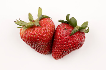 Two strawberries on white background.