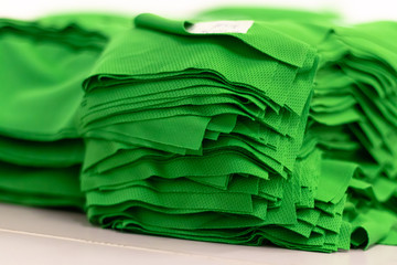 Cloth sports mesh folded into a stack of bright green color close-up. Sewing industry.