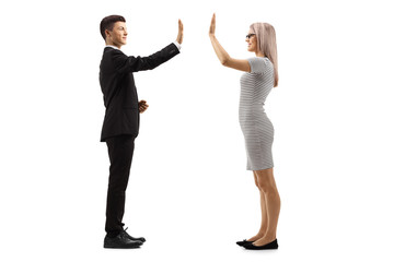 Young man in a suit gesturing high-five with a young woman