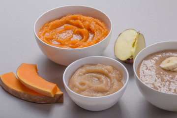 Bowls with healthy baby food on color background. Purees, made of fresh organic fruit and vegetables, flay lay, top view, concept. Kids meal