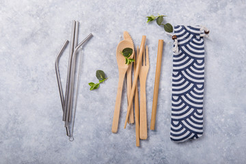 eco-friendly reusable metal drinking straw and cutlery  ( spoon, knife, fork) on wooden table. zero waste concept