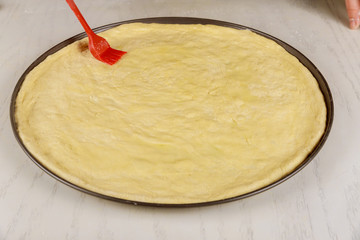 Preparing dough for making round pizza.