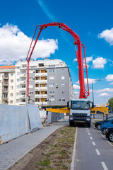 Concrete mixer truck pumping concrete on a foundation of the new building under construction