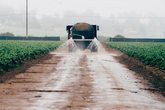 Water Spraying On Dirt Road From Truck In Farm