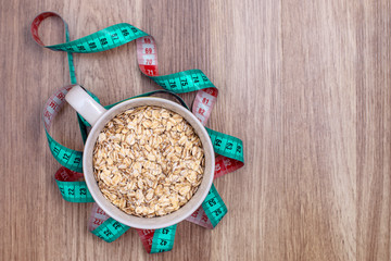 an inch for sewing turquoise and red around a white Cup with oatmeal on the wooden floor