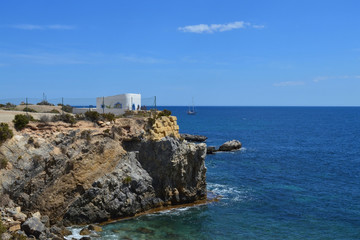 Fototapeta na wymiar Rock cliff with building in sea