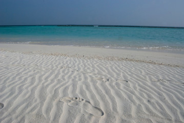 Fototapeta na wymiar Orma di piede sulla sabbia bianca 