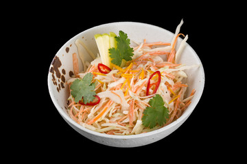 Vitamin salad from cabbage and apples. Served in a plate. Isolated on a black background.