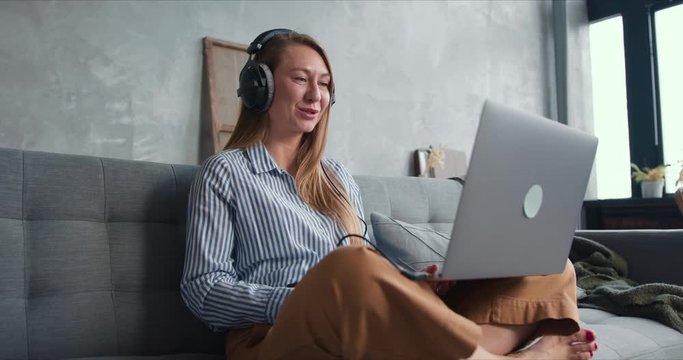 Working from home on self isolation. Happy young cheerful blonde woman using laptop for video call talking on quarantine