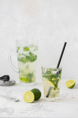 Classic mojito cocktail in a glass. In the background is the decanter and the bartender's instruments.