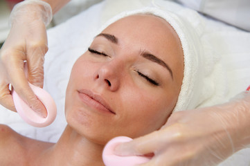 Obraz na płótnie Canvas Happy female getting facial massage alternative medicine top view