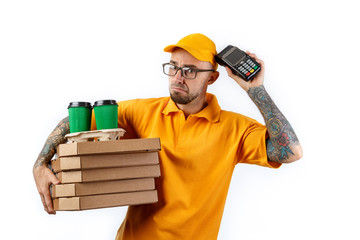 Friendly young man from a courier delivery service holds in his hands boxes of pizza and a terminal for cashless payments on a white background