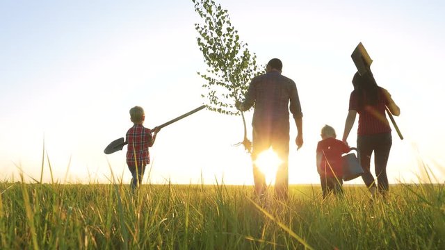 agriculture red neck farming happy family walking agriculture of farmers a silhouette concept slow motion video. mom dad son and daughter walk go children happy lifestyle family plant and water the