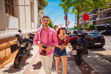 Couple of tourists exploring new city together and making photo on a instax camera