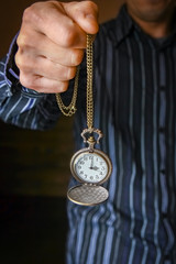a pocket watch in the hands of a man