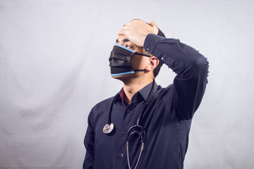masked doctor touches his forehead