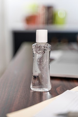 Hand sanitizer bottle, mockup dispenser alcohol gel, on desk home office, laptop paperwork antibacterial coronavirus quarantine isolation, small squeezable dispenser